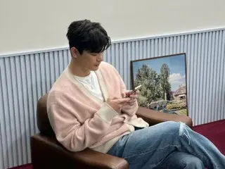 Seo In Guk, 핑크 가디건으로 여유 있는 모습… 스마트폰으로 무엇 보고 있을까?