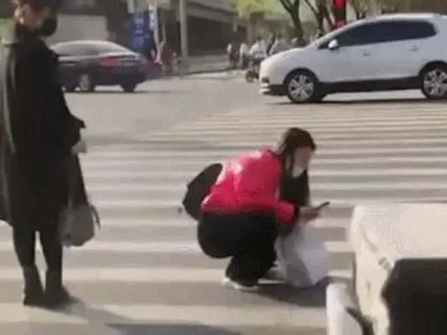 중국에서 어머니로 보이는 여성이 아기를 횡단보도에 놓고 스마트폰으로 계속 촬영하는 모습이 한국에서도 파문 펼친다. .