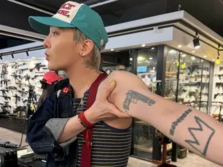 지드래곤(빅뱅), 권총점을 찾아 팔에 있는 총 문신을 보여준다